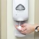 Using hand sanitizer on dispenser