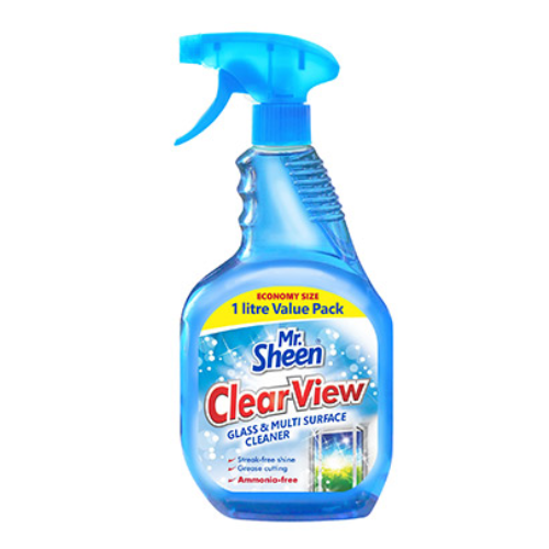 Person applying anti-fog glass cleaner spray to a car windshield for improved visibility.